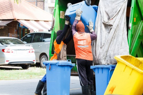 Rubbish removal crew handling green waste safely